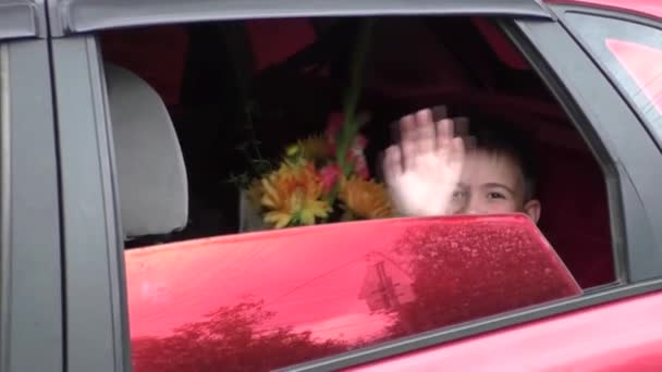 Der Junge setzt sich mit seinen Eltern in ein Auto — Stockvideo