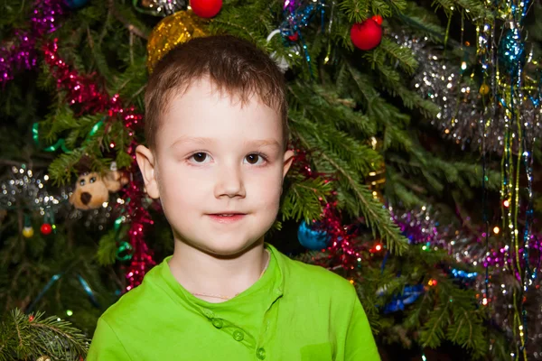 Χαρούμενο αγόρι κοντά ένα χριστουγεννιάτικο δέντρο — Φωτογραφία Αρχείου