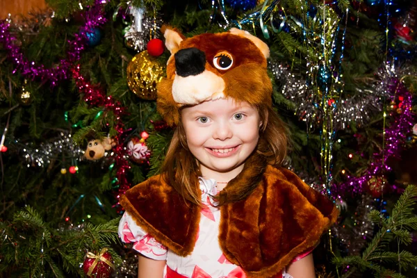 Χαρούμενο κορίτσι σε ένα κοστούμι σκίουροι γύρω από ένα χριστουγεννιάτικο δέντρο — Φωτογραφία Αρχείου