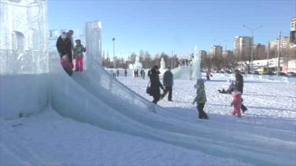 Dauerwelle, Russland, 6. Februar 2016: Fröhliche Kinder fahren auf Spielrutschen — Stockvideo