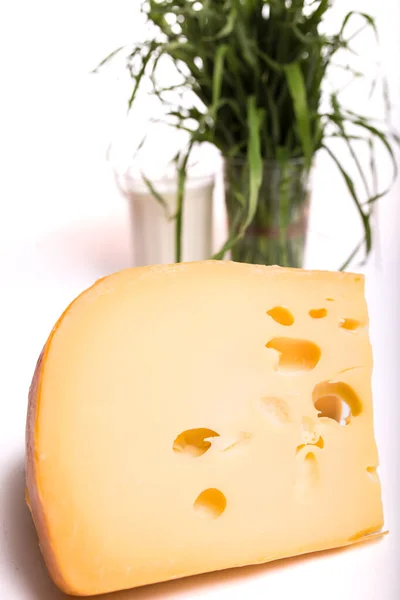 チーズが閉じられ 背景に緑の芝生のミルクのガラスがブルーになっています — ストック写真