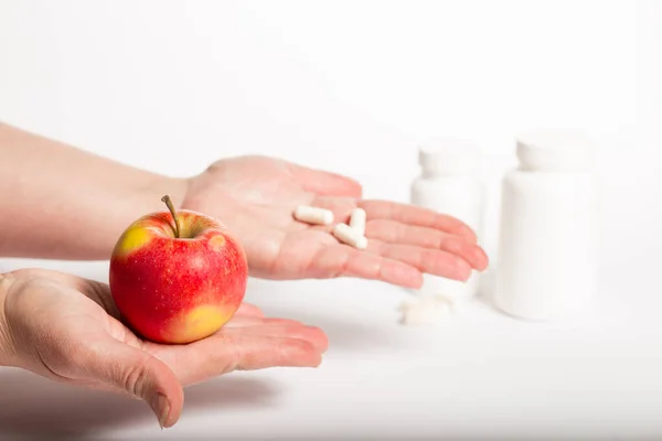Czerwone Jabłko Jednej Ręce Tabletki Drugiej Białym Tle — Zdjęcie stockowe