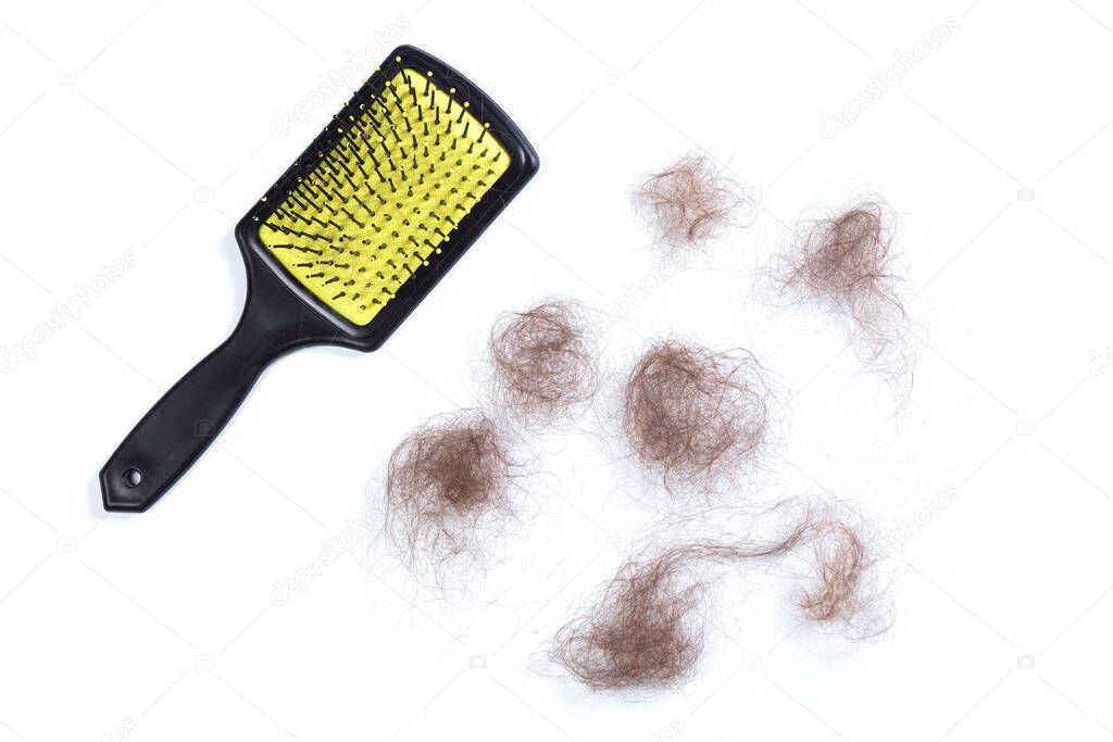 Loose hair clumps and hair brush on white background.