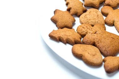 Zencefilli kurabiyeler beyaz bir tabakta ve beyaz bir tabakta kapanıyor..