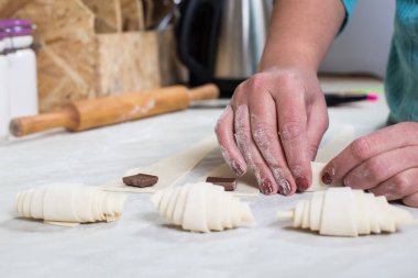 Mutfakta çikolatalı kruvasan yapan eller..