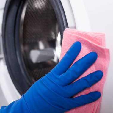Çamaşır makinesini temizleyen mavi eldivenleri teslim et..