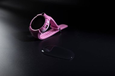 Pembe Chindren 'in su geçirmez, siyah zemin üzerinde su damlası olan akıllı saati..