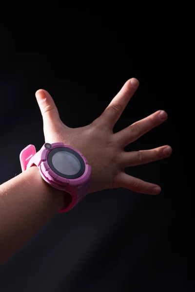 粉红智能手表的儿童手 黑色背景 — 图库照片