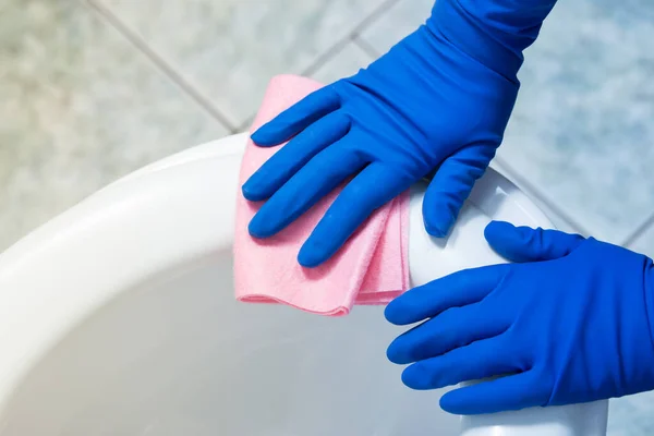 手戴蓝色手套 用粉红布清洁厕所 — 图库照片