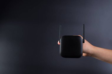 Siyah arkaplanda, kopyalama alanı olan siyah kablosuz ağ yükselticisi.