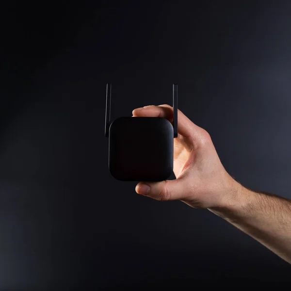 Hand Verbindet Schwarzen Wifi Verstärker Mit Steckdose Auf Schwarzem Hintergrund — Stockfoto