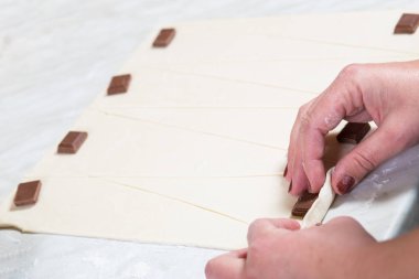 Pasta şefinin elleri çikolatalı kruvasan yapıyor..