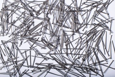 Beyaz arka planda tahta için küçük metal çiviler yığını.