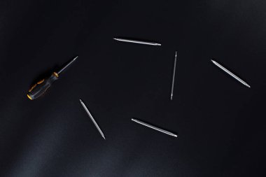 Küçük elektronik tamir tornavidaları ve siyah arkaplan üzerindeki diğer araçlar.