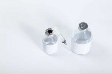 Cam şişelere temiz etiketli aşı enjeksiyonu. Fotokopi alanı olan beyaz bir arka plan..