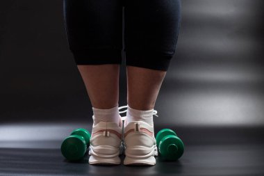 Şişman kadın, spor salonunda dambıllarıyla yaz için hazırlanıyor..