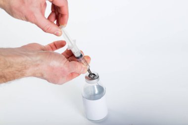 Eller, telif uzayı olan beyaz bir zemin üzerinde tıbbi cam kaplardan aşı çizer..