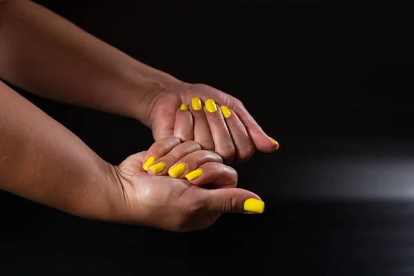 Жовтий Манікюр Дівчині Таніровані Руки Чорному Тлі — стокове фото