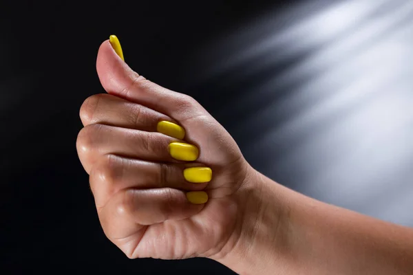 Ręka Żółtym Manicure Zbliżenie Czarnym Tle — Zdjęcie stockowe