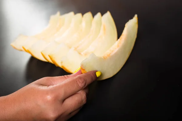 Female Hand Yellow Manicure Holding Ripe Melon Sliced Black Background — Stock Photo, Image