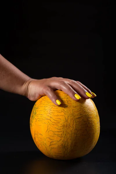 Female Hand Yellow Manicure Holding Ripe Melon Black Background — Stock Photo, Image