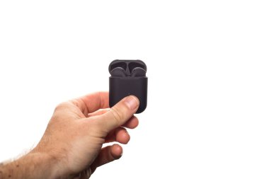 Elinde kablosuz siyah kulaklıklar, kopyalama alanı olan bir beyazda izole edilmiş..