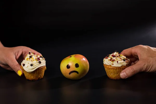 Duas Mãos Escolhendo Cupcakes Doces Contra Maçã Fresca Fundo Preto — Fotografia de Stock