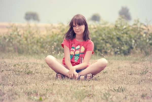 Adolescente chica sentado en la hierba — Foto de Stock