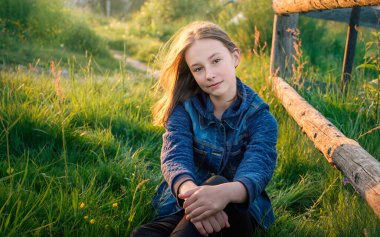 Baharda yeşil çimlerde çiçekli genç kız portresi