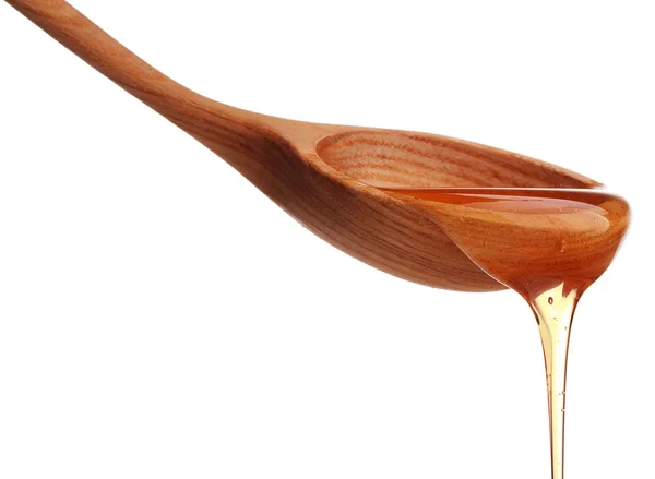 Honey dripping from wooden spoon — Stock Photo, Image