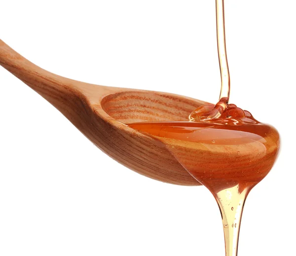 Honey dripping from a wooden honey dipper — Stock Photo, Image