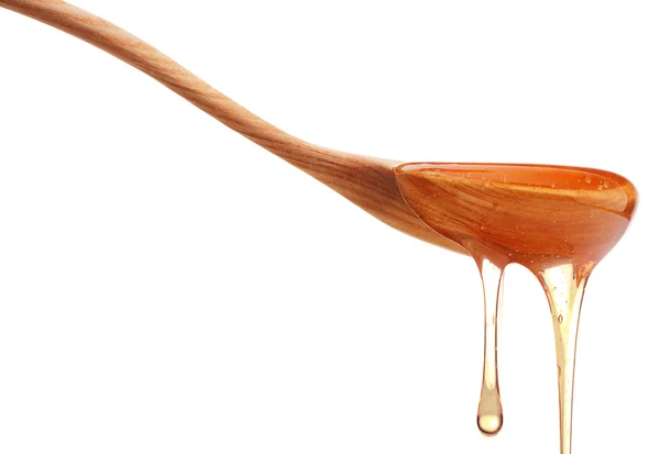 Honey dripping on wooden spoon — Stock Photo, Image