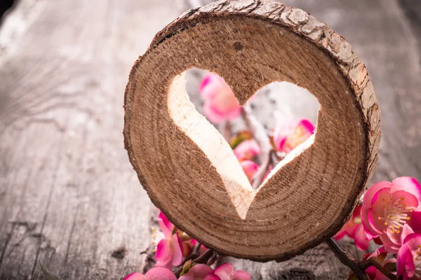Hjärtat hål i trä och blommor — Stockfoto