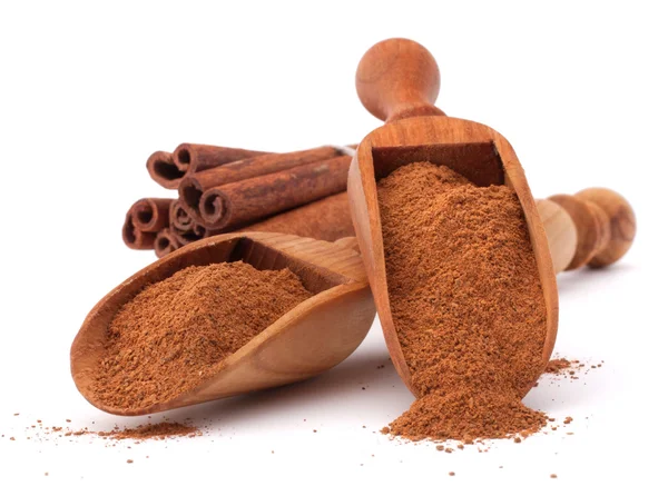 Cinnamon sticks  and powder in wooden scoops — Stock Photo, Image