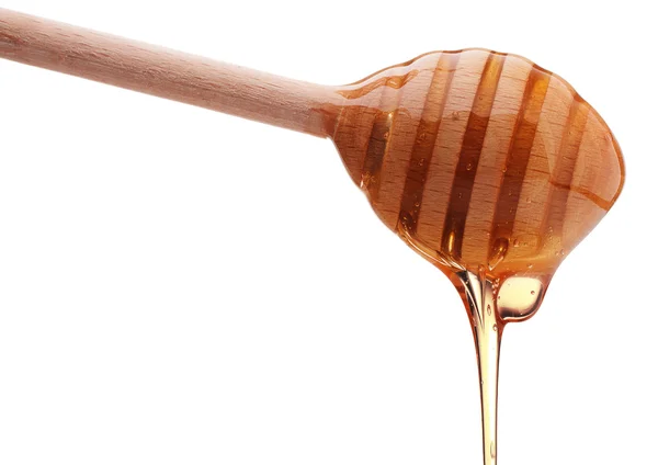 Honey dripping from wooden honey dipper — Stock Photo, Image