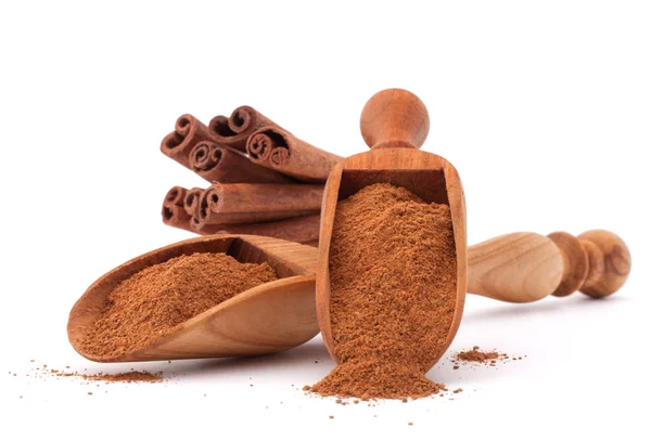 Cinnamon sticks  and powder in wooden scoops — Stock Photo, Image