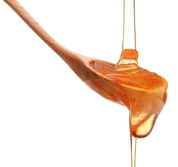 Spoon with pouring honey — Stock Photo, Image