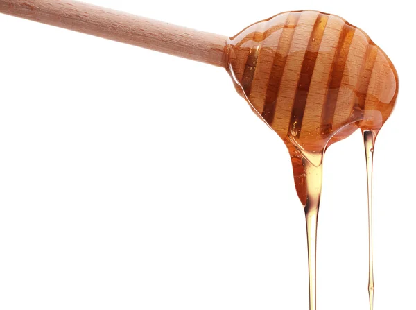 Honey dripping from a wooden dipper — Stock Photo, Image