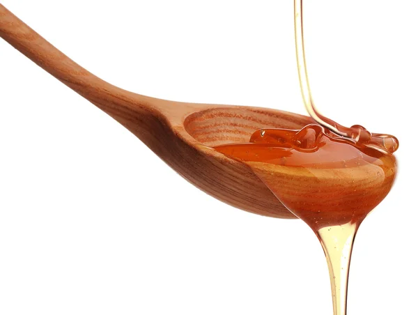 Honey dripping from a wooden dipper — Stock Photo, Image