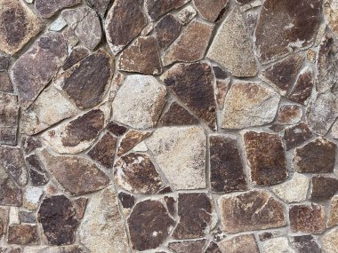 Doğal Taş Duvar dokusu Düzensiz Rock Masonry Kahverengi Çakıl Taşı Yüzey Arkaplan Fotoğrafı.