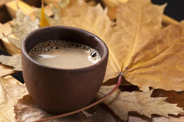 Koffiekopje en Herfstbladeren op een houten tafel. — Stockfoto