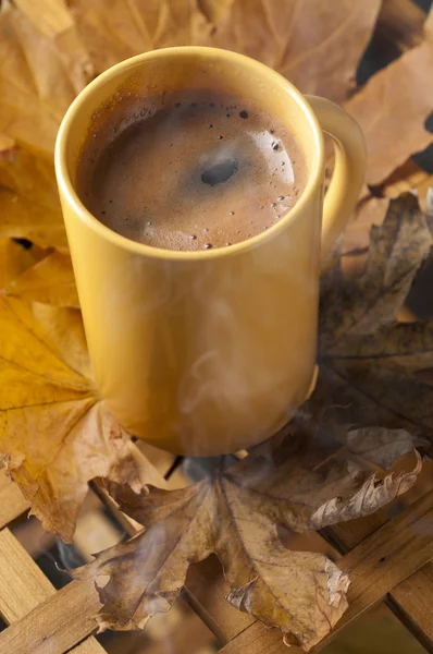 咖啡杯和秋天的落叶，木制的桌子上. — 图库照片