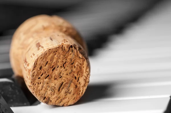 Wine cork on piano keyboard — Stock Photo, Image