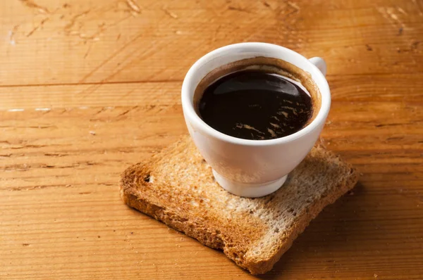 Filiżanka kawy espresso z toast na drewnianym stole — Zdjęcie stockowe