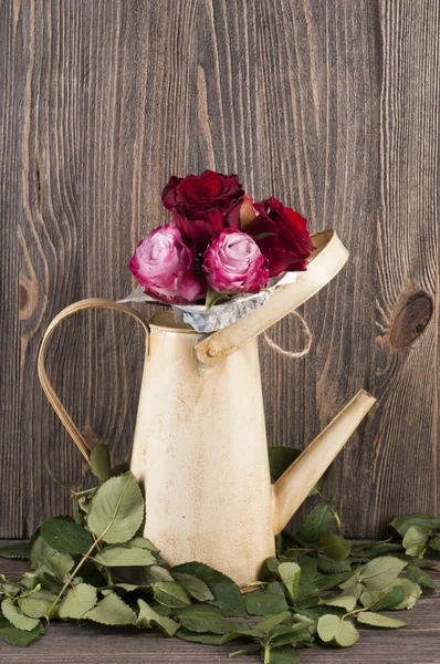 Букет з різнокольорових троянд в поливі може над дерев'яним нарцисом — стокове фото