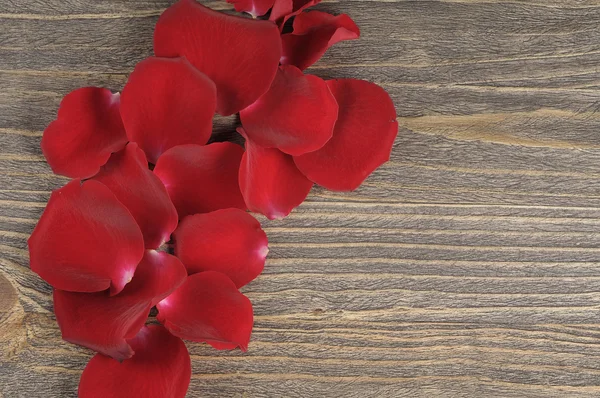 Pétalos de rosa sobre fondo de madera . — Foto de Stock