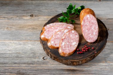 Sosis. Ahşap servis tahtasında baharatlı füme sosis. Hindi etinden yapılmış lezzetli et sosisleri. Kopyalama alanı