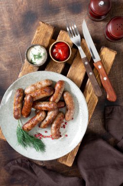 Bavyera sosisi. Kahverengi ahşap bir masada bir tabakta domuz sosisi. Nefis Nuremberg sosisleri