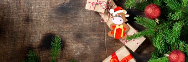 Mutlu yıllar 2021 kutlamaları. Köknar dallı Noel arkaplanı 2021 boğa ineğinin sembolü ile süslenmiştir. El işi kağıt hediye kutularıyla Noel arkaplanı. Pankart. Kopyalama alanı