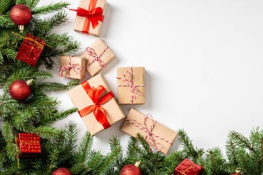 El işi kağıdında hediye kutuları. Noel arkaplanı. Beyaz arka planda ahşap süslemelerle süslenmiş ladin dalları altında Noel hediyeleri. Kopyalama alanı